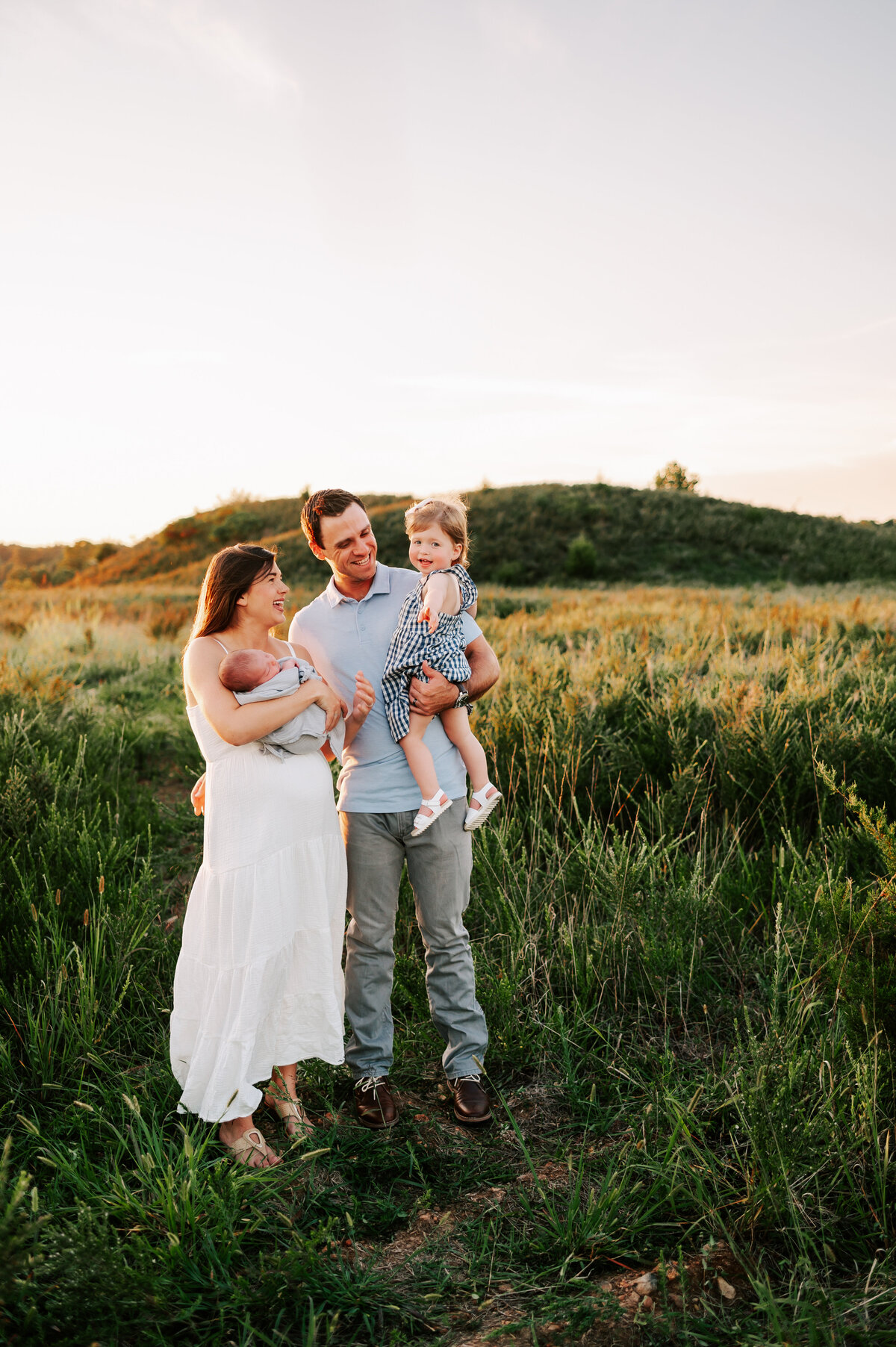 Branson MO  family photographer The XO Photography captures family hugging in a field