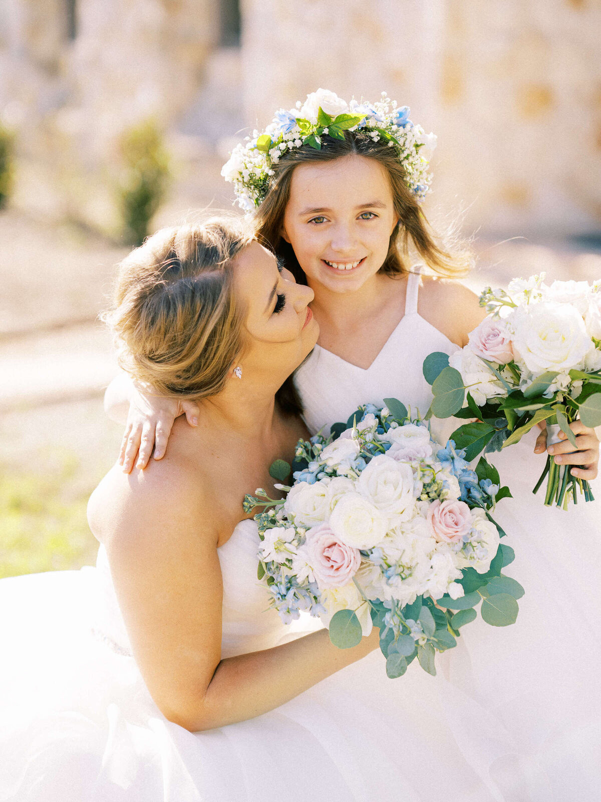 Junior bridesmaid with flower crown poses with bride at spring wedding in North Texas