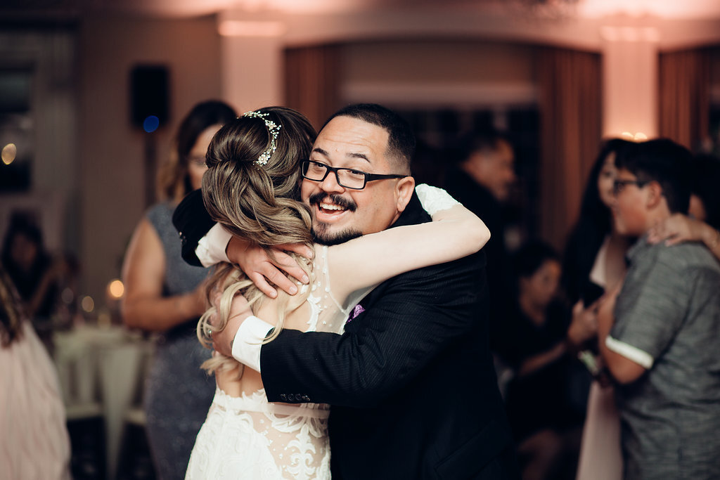 Wedding Photograph Of Man With Eye Glasses Hugging The Bride Los Angeles