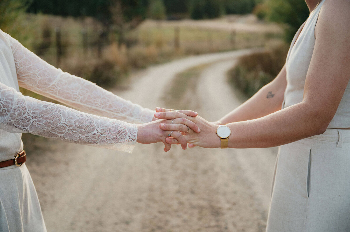 Faceless arms with hands intertwined on a dirt road