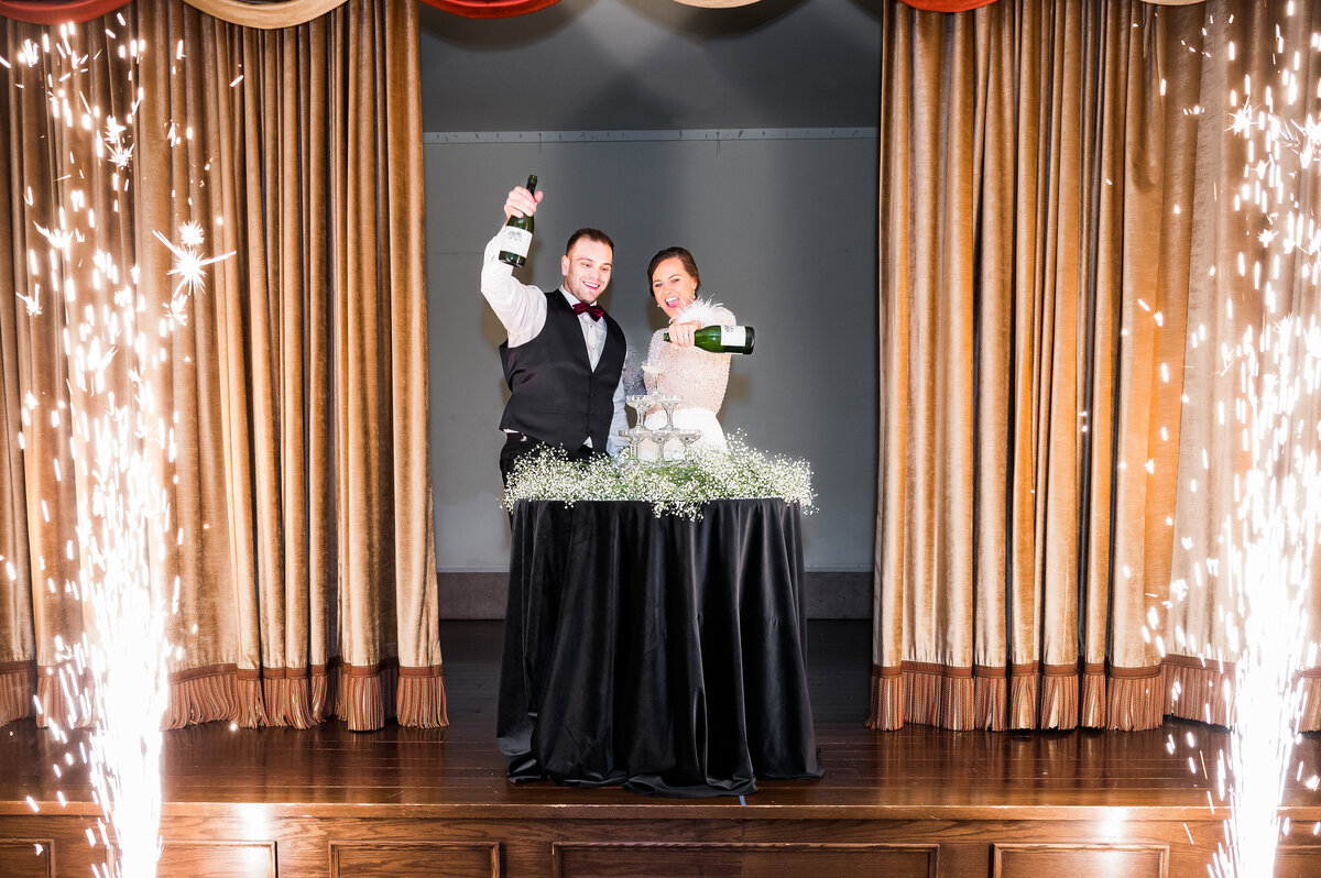 bride and groom pouring a champagne tower at new years eve wedding