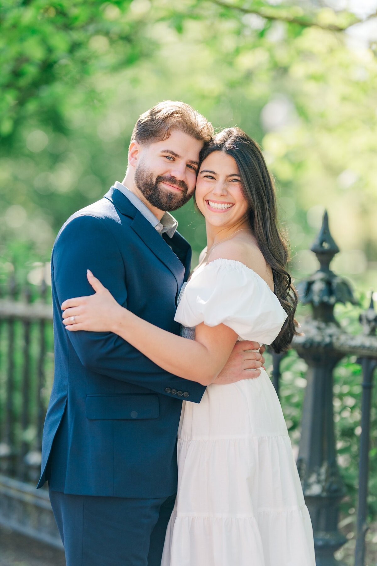 A woman and her fiancé smiling under a tree at Boston public Garden