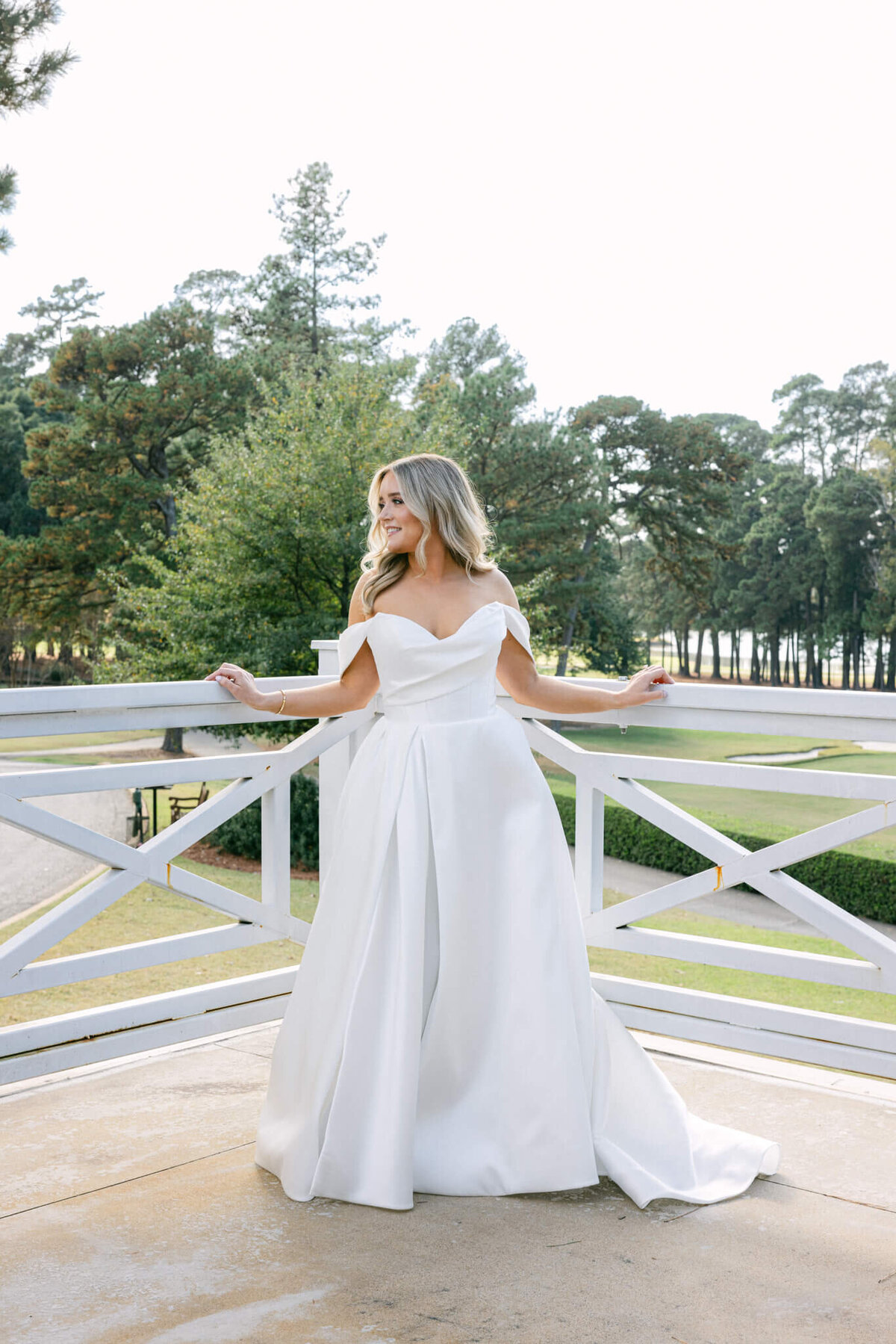 A wedding day photo of the bride in her white wedding dress posing for a portrait
