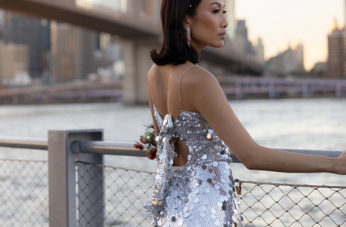 A close-up shot of the bride’s shimmering sequin dress as it catches the light under the bridge.
