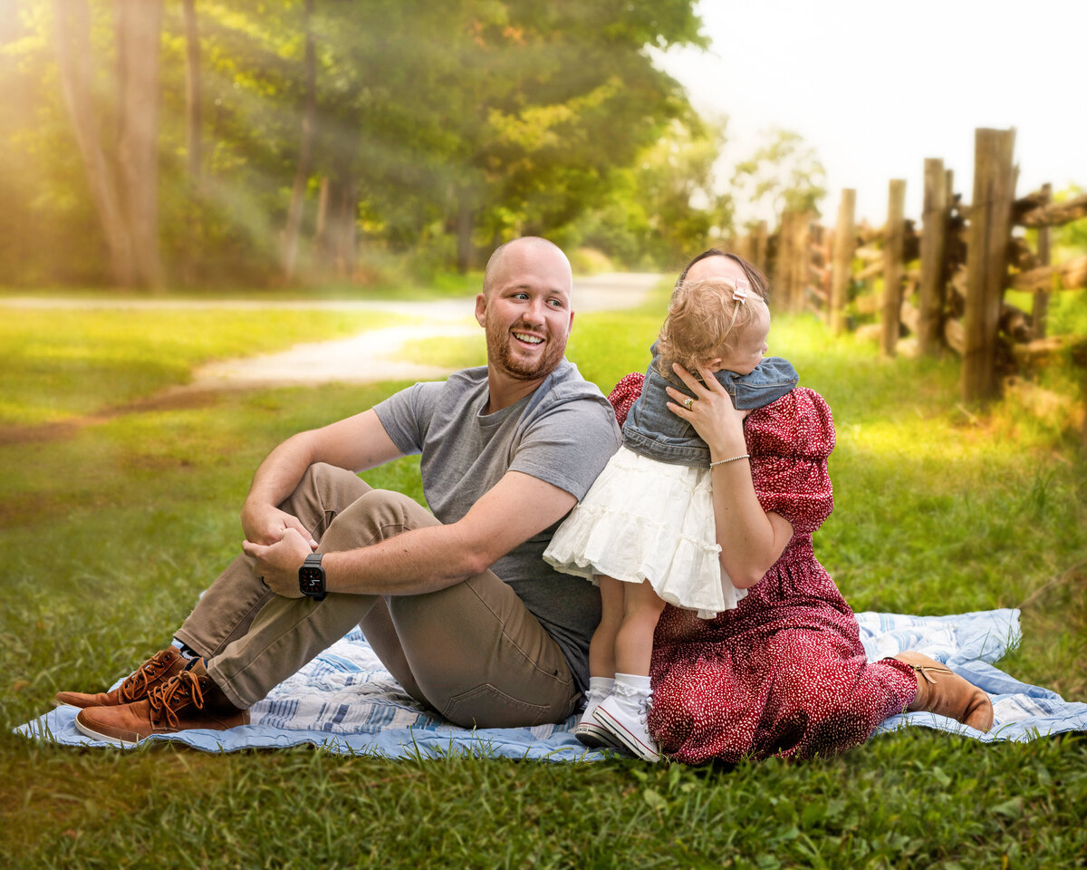 Candid outdoor family portrait at Bronte Provincial Park in Oakville, Ontario, featuring joyful toddler interaction and warm natural light.