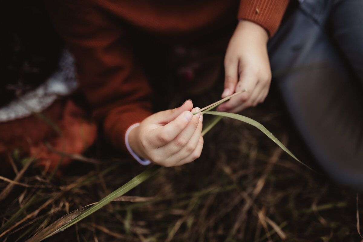 boy holding blade of grass