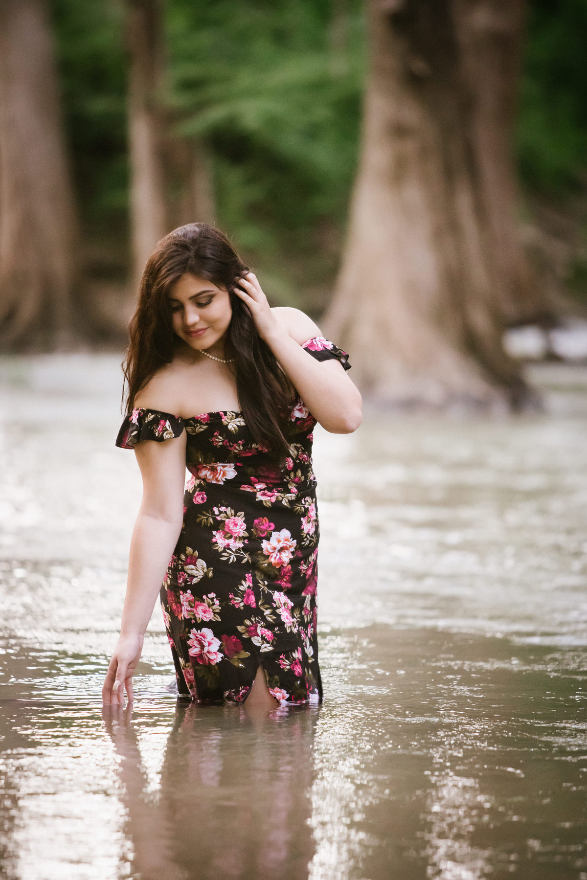 high school senior girl standing in river water in dress by San Antonio senior photographer