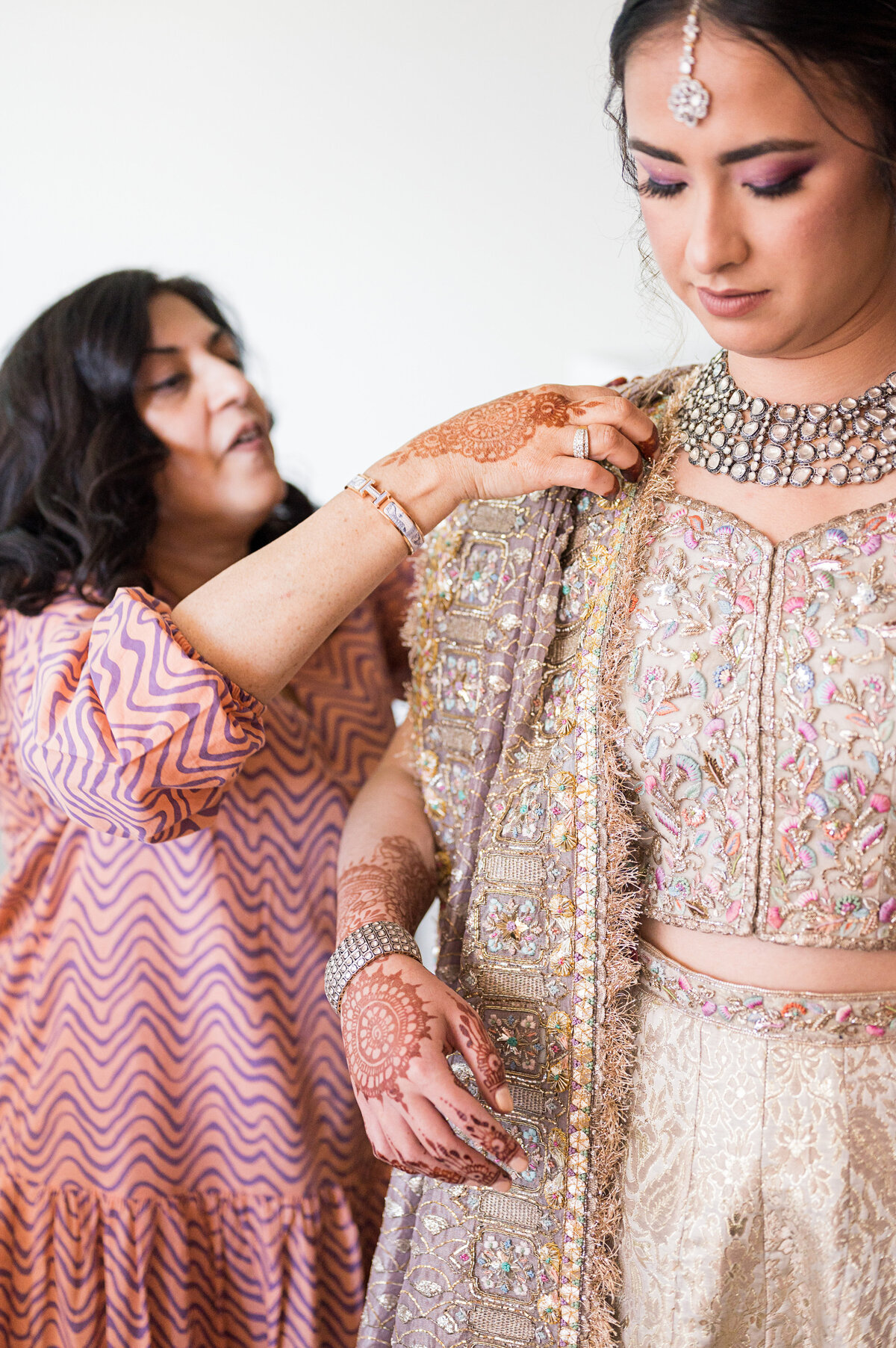 aunt helping bride with pakistani choli