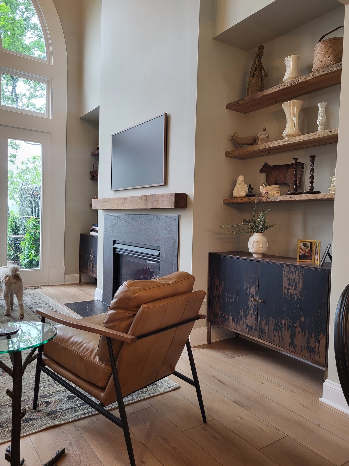Fireplace with antique wood mantle and antique wood bookshelves in the nooks beside the fireplace with artisticaly painted black and tan cabinets