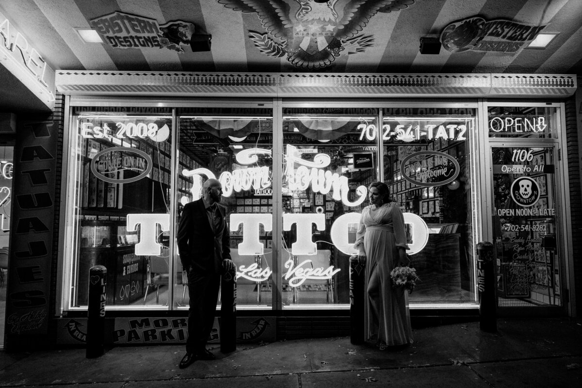 A couple poses in front of a tattoo shop in Las Vegas.