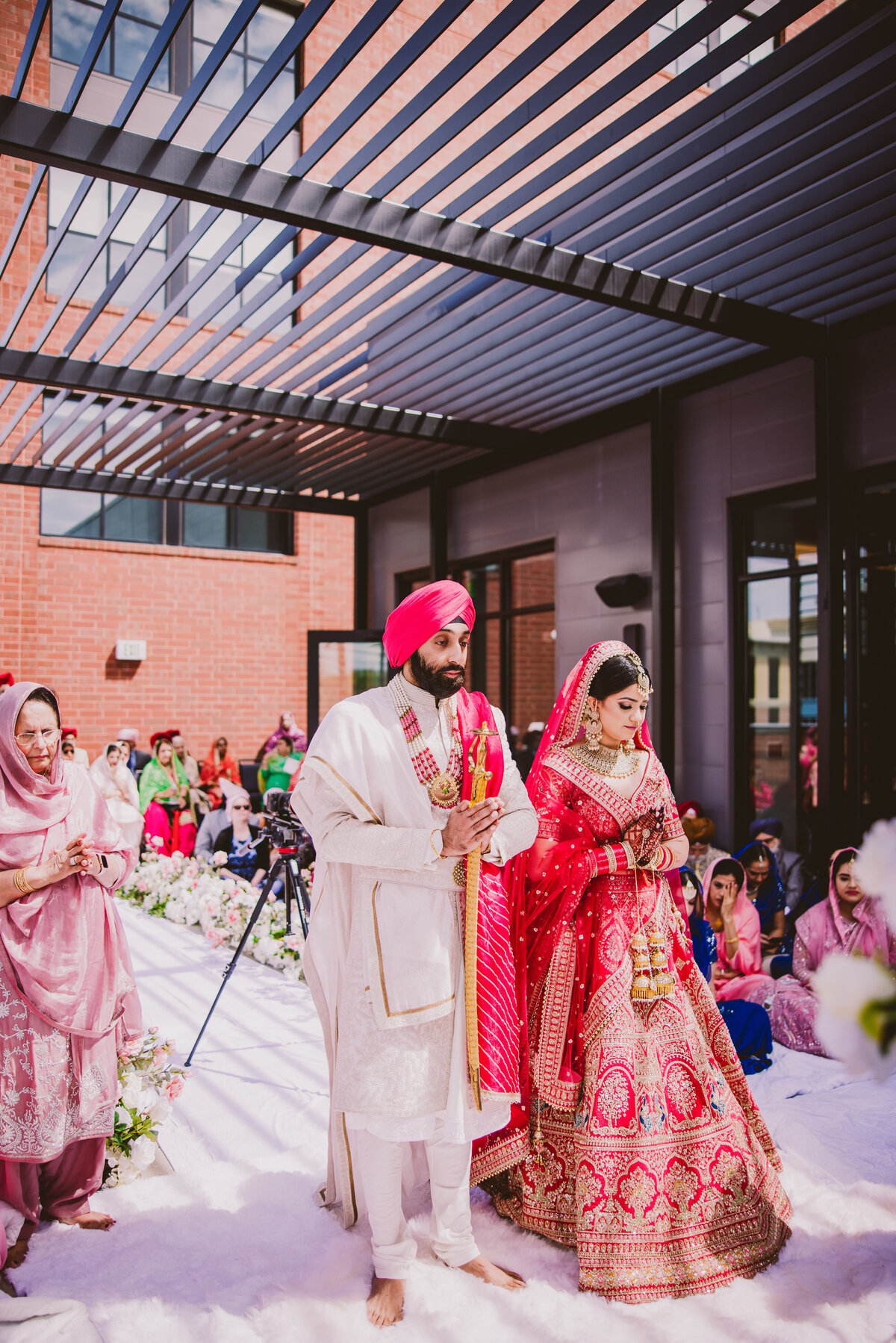 An indian sikh bride and groom praying during the anand karaj wedding ceremony and getting married at the marriott owing mills in maryland