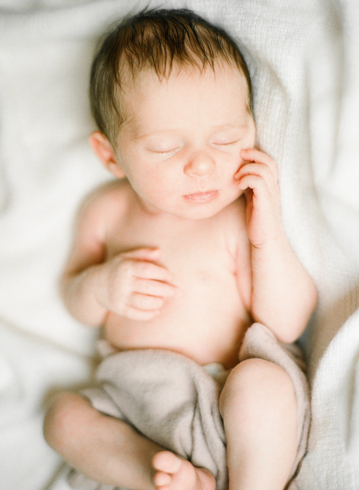 newborn baby girl cuddled in soft linens rochester minnesota home