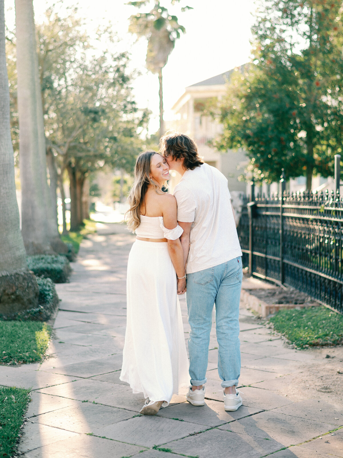 bride in white dress walking down the streets of galveston with groom