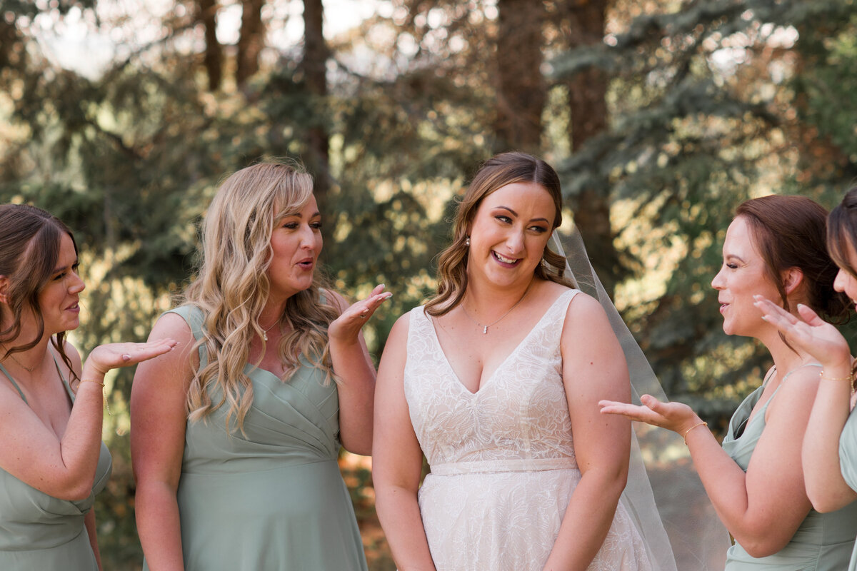 bride and her maid of honour looking at each other laughin