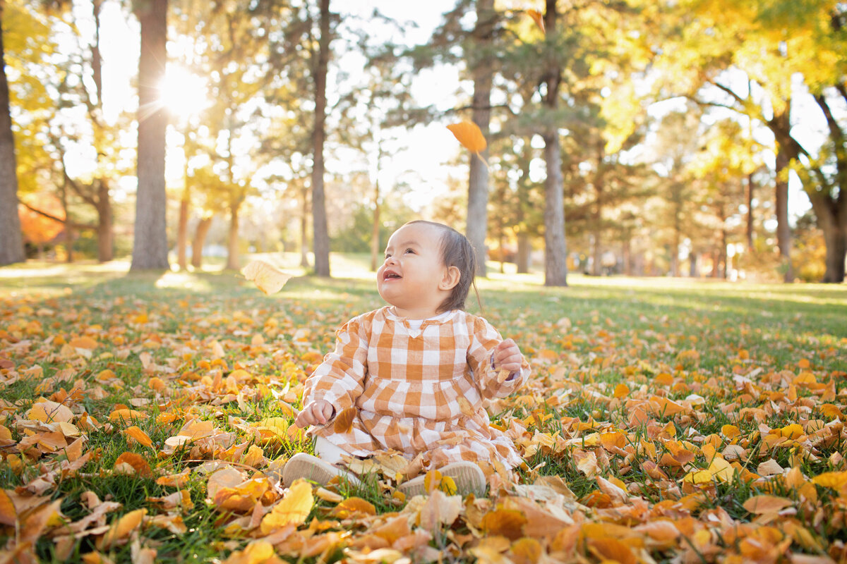 toddler in fall leaves