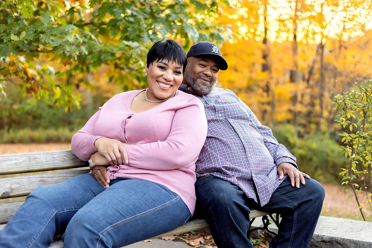 Husband and wife sitting on bench in a park