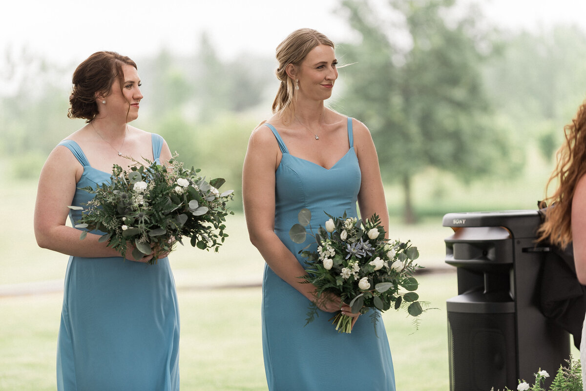Groom watching bride walk aisle