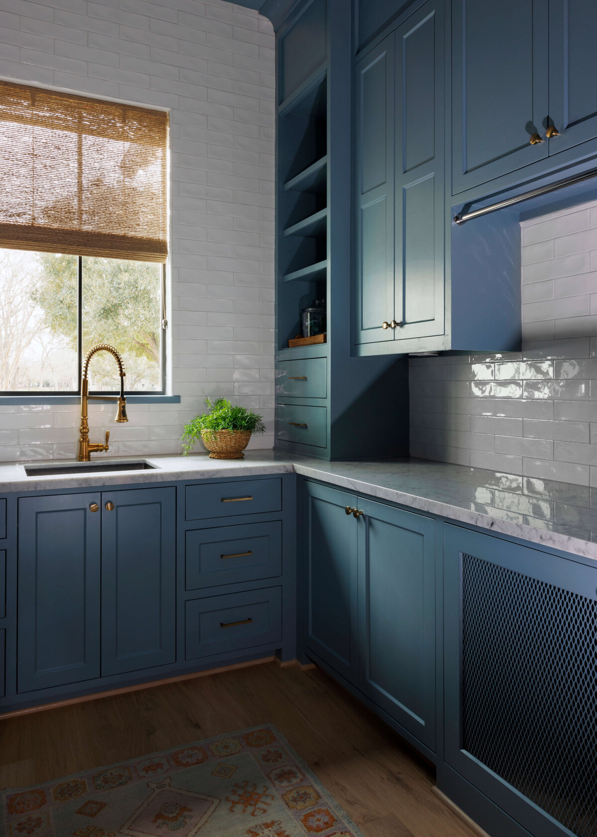 oyster creek studios missouri city new build dark blue kitchen with gold hardware and white subway tile wall