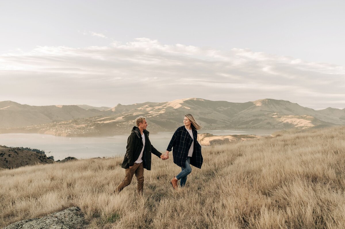 couple engagement christchurch port hills walk winter coats sunrise candid portrait