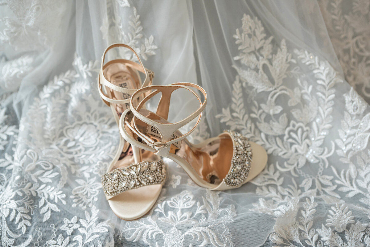 Bride wedding heels sitting on dress.