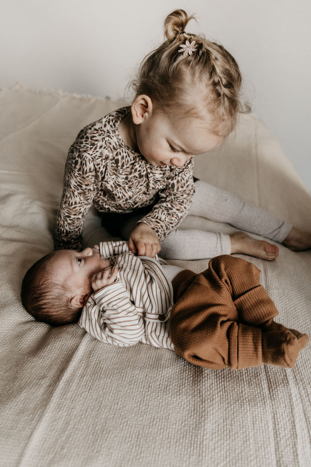 Zusje samen met haar newborn broertje tijdens de ontspannen newbornshoot