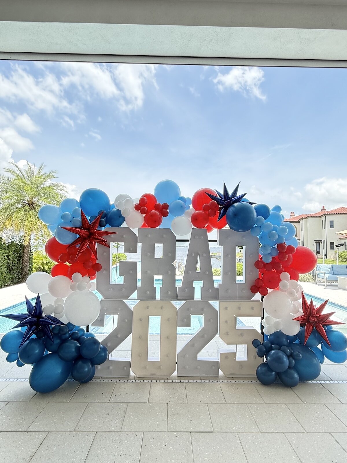 Balloon garland and backdrop in navy, blue, red and white in fort myers, florida for a graduation party.