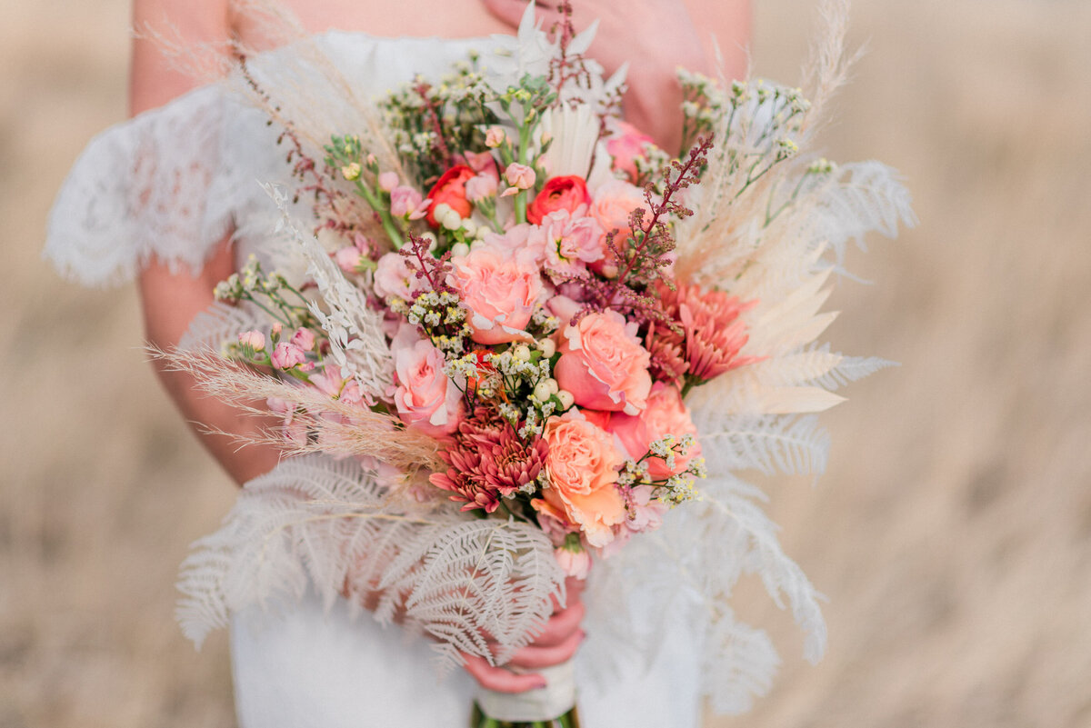 Beautiful floral arrangement with pops of peach, apricot, pink.
