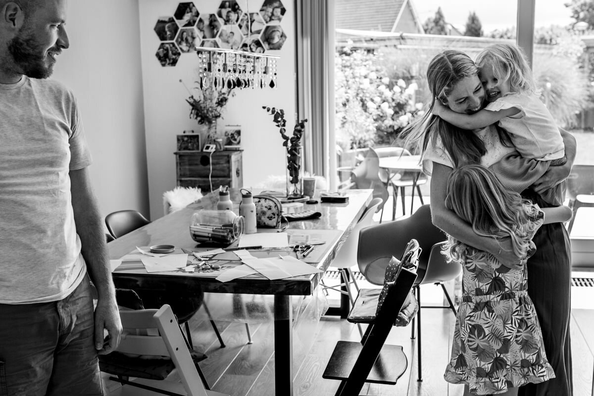 gezin thuis odchters knuffelen mama