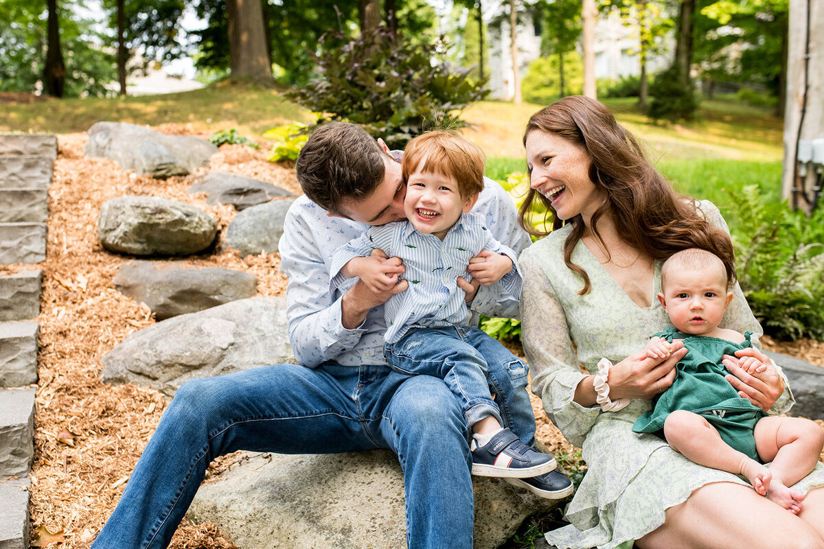 Family of four laughing and enjoying a sunny day in a park during a fun-filled family photo session in the Eastern Townships