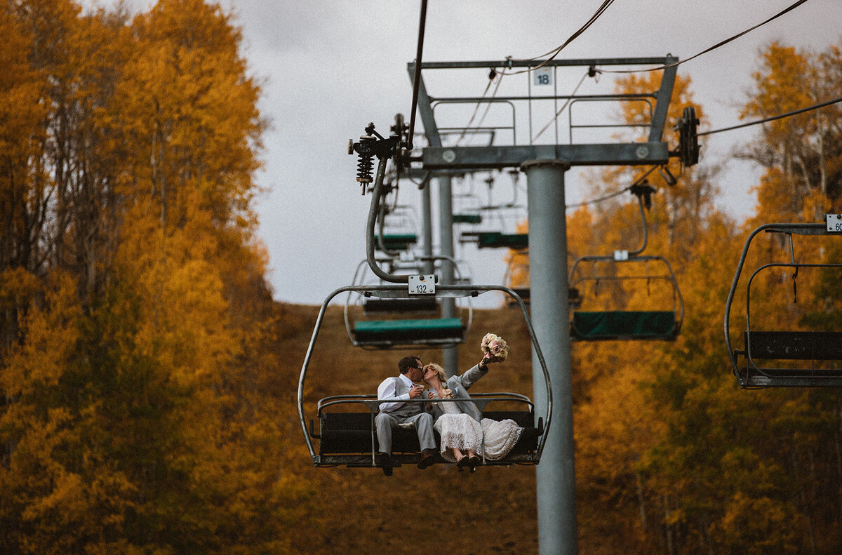 married couple riding ski gondola in  aspen
