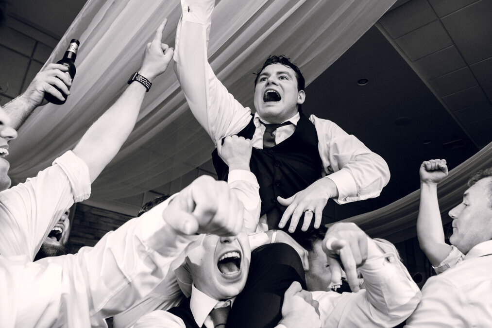 A group of groomsmen celebrating in the air.