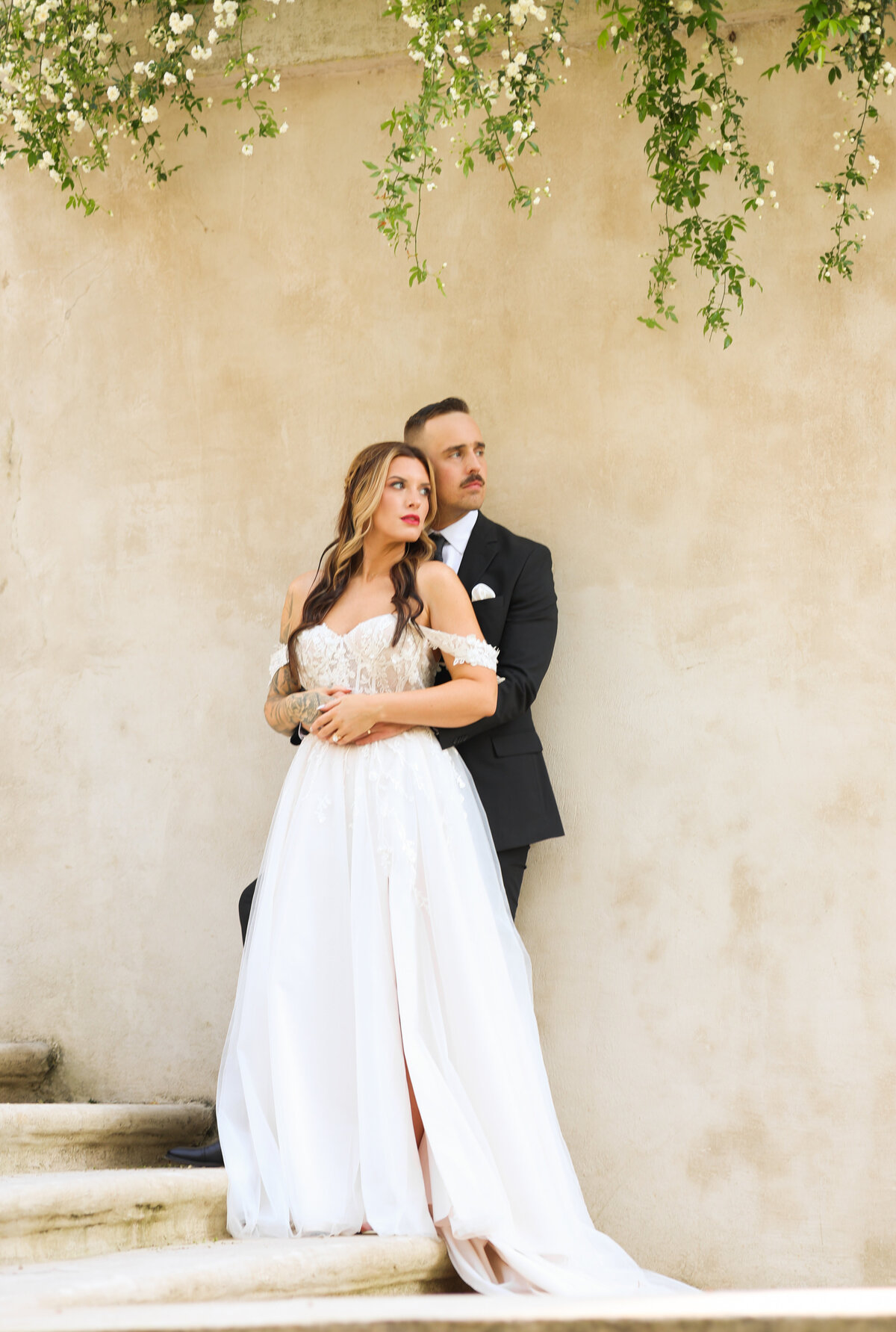 bride and groom hugging and standing in front of marble steps and flowers at The Swan House in Atlanta Georgia by Atlanta Georgia wedding photographer Amanda Richardson Photography