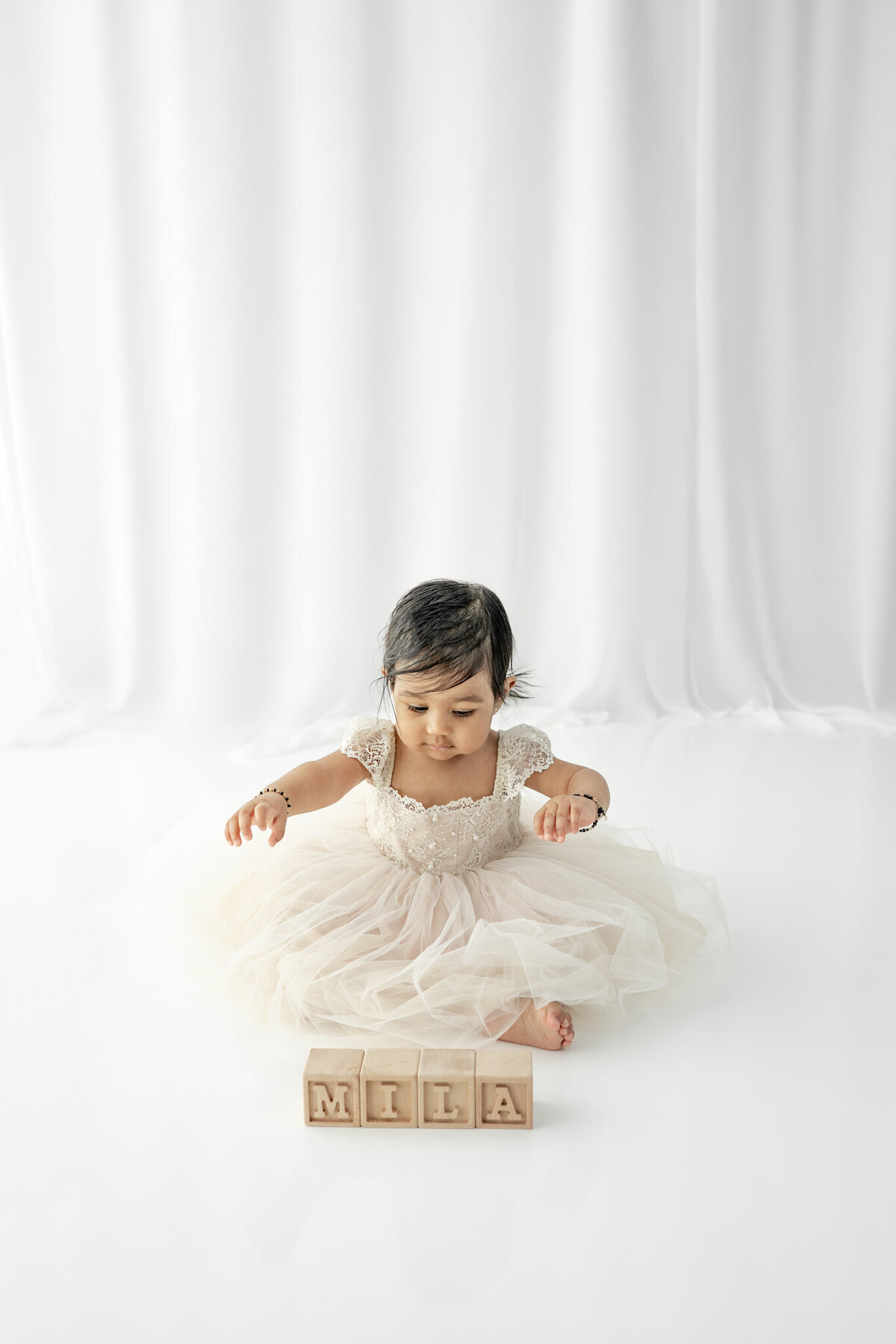Girl in dress sitting during a cake smash session— captured by Alliston and Barrie cake smash photographer.