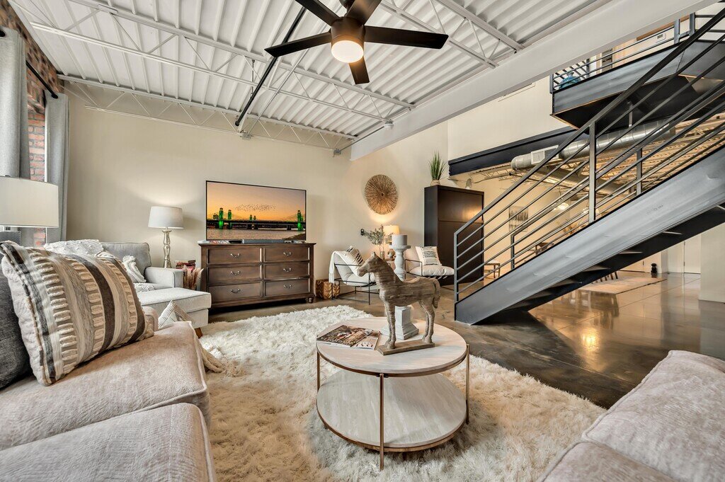 Living room with plenty of comfortable seating and smart TV in this 2 bedroom, 2.5 bathroom luxury vacation rental loft condo for 8 guests with incredible downtown views, free parking, free wifi and professional decor in downtown Waco, TX.
