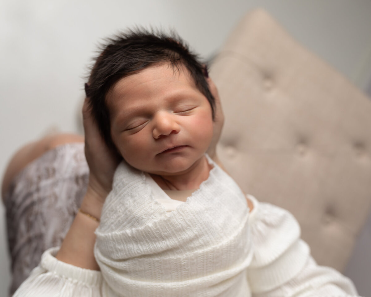 newborn baby boy wrapped in white for studio portraits