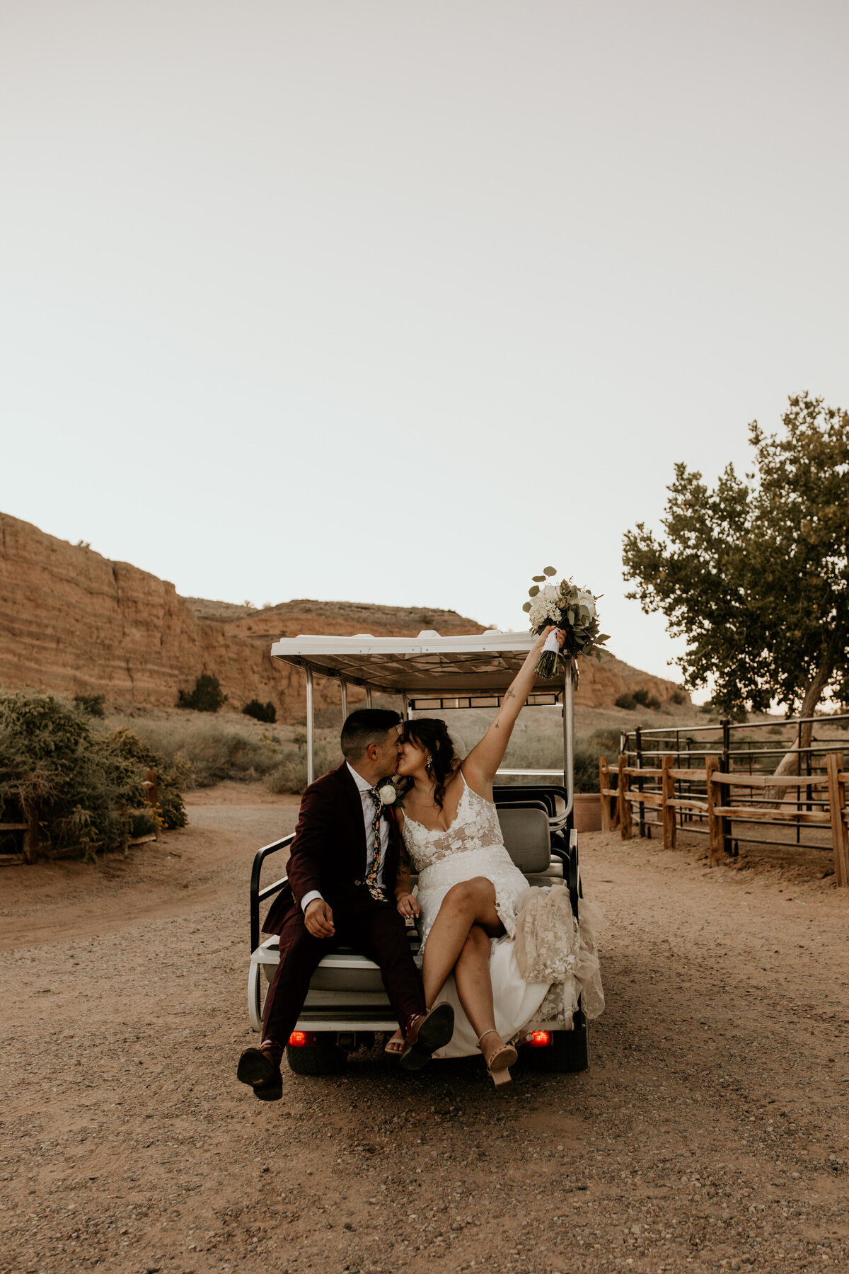 bride and groom sitting on the back of a golf cart in Albuquerque