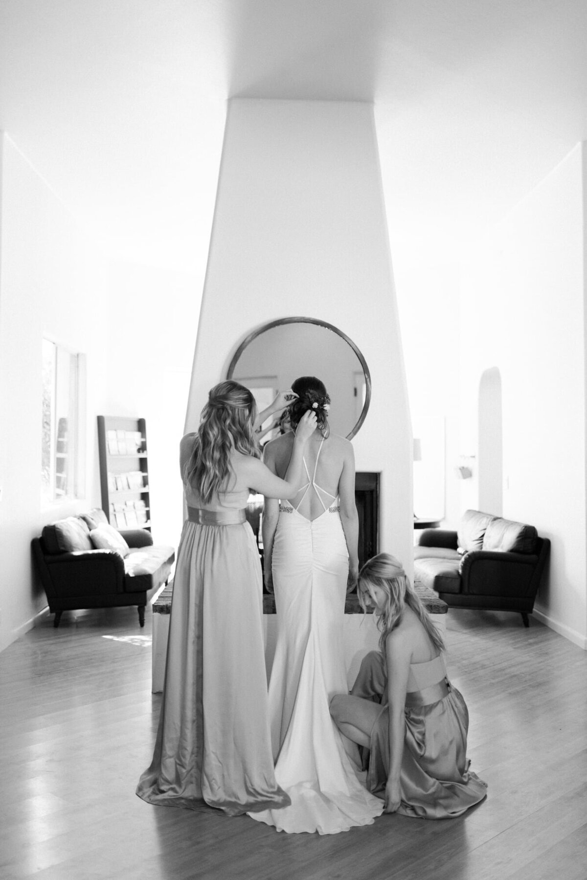 Bridesmaids helping bride with dress and hair at private residence in Scottsdale