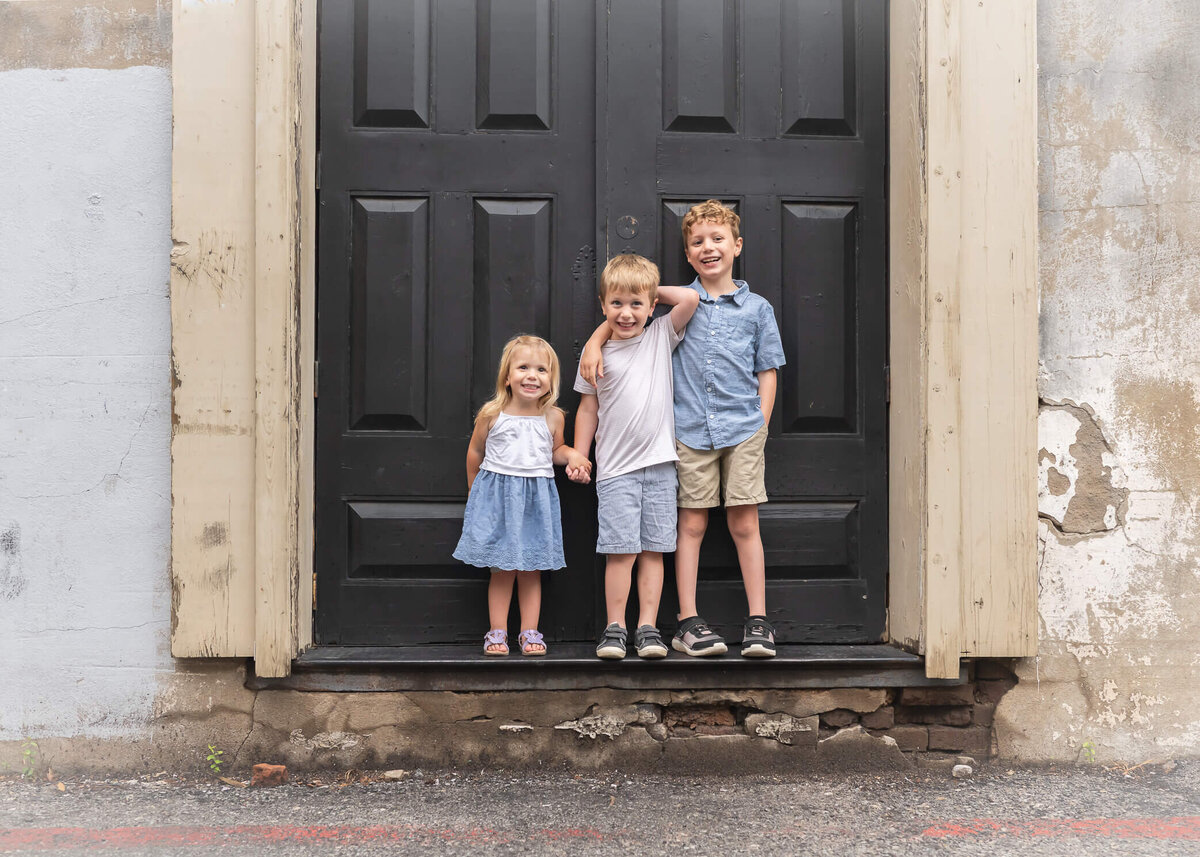 gorgeous blonde kids in a doorway in Downtown McKinney captured by Allison Amores Photography