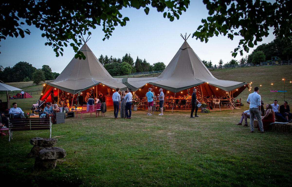 Guests standing outside Greehill Farm wedding yurt at night