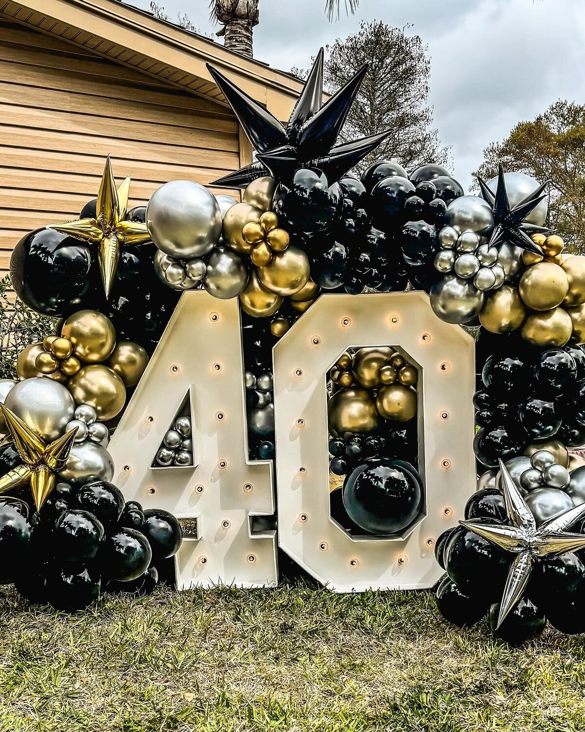 40 marquee numbers with black and gold balloons
