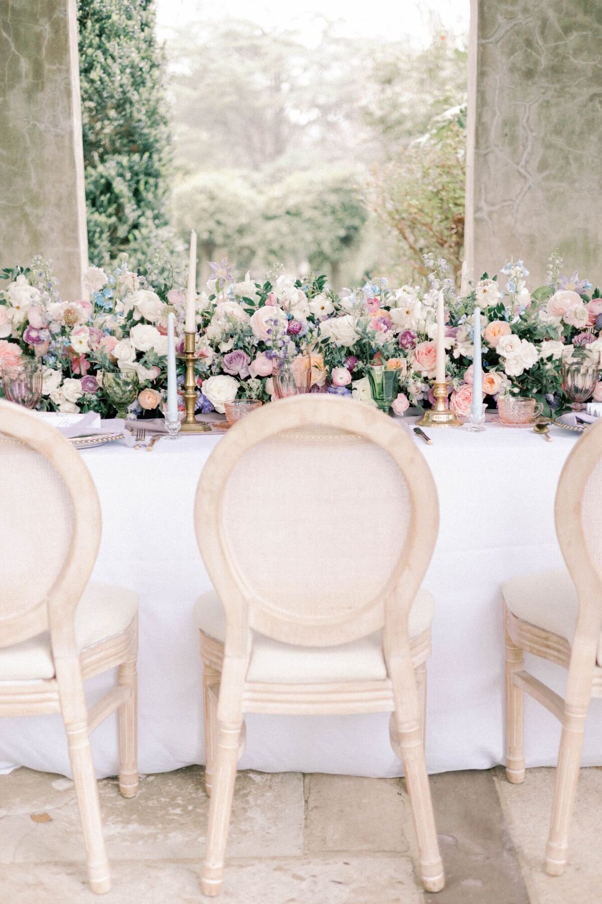 Wedding chair at table with large bouquets of flowers.