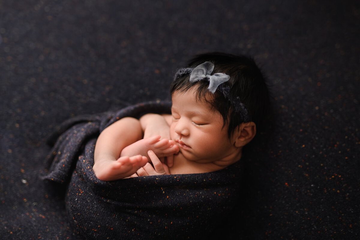 Dark blue styled portrait of newborn girl