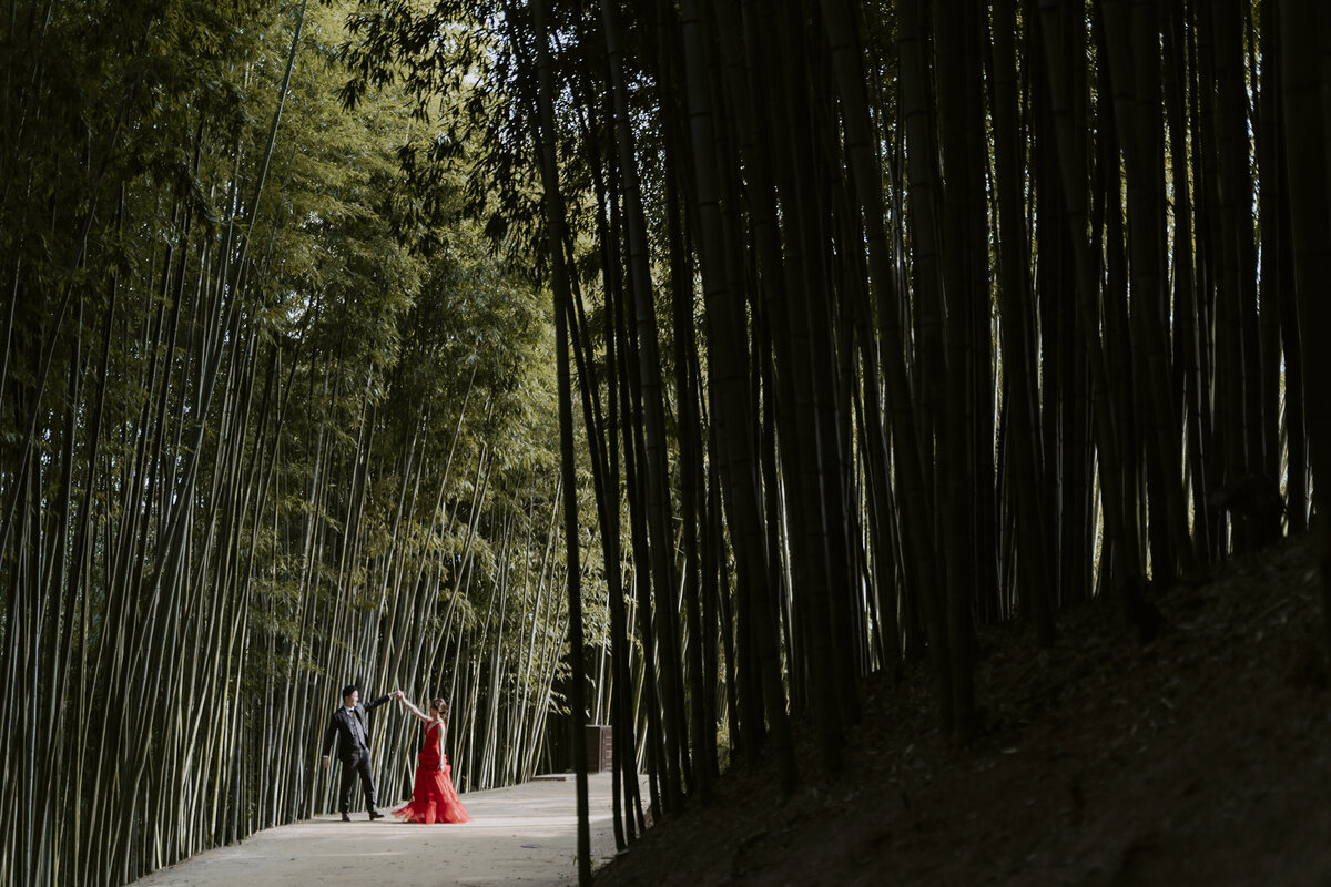 a Singaporean couple dance in the bamboo forest during their prewedding photoshoot