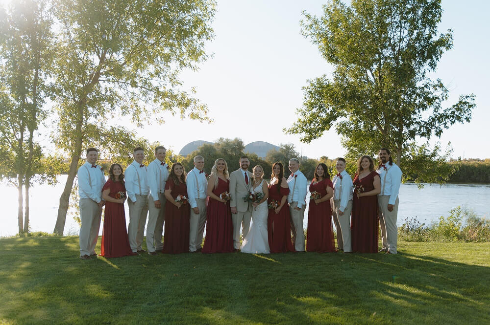 A portrait of all the bridesmaids and groomsmen staggered with the bride and groom in the middle.