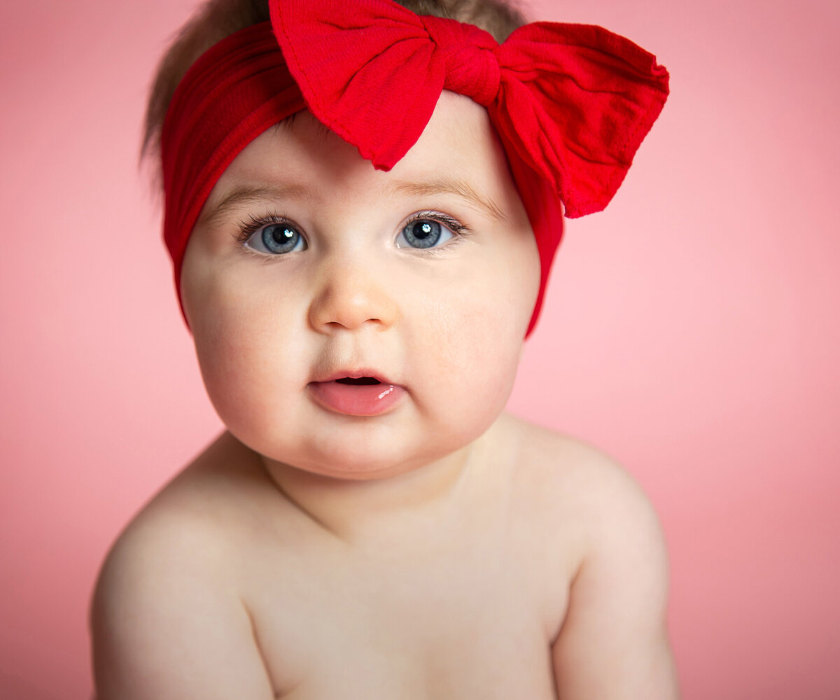 sweet nine month old baby with red bow