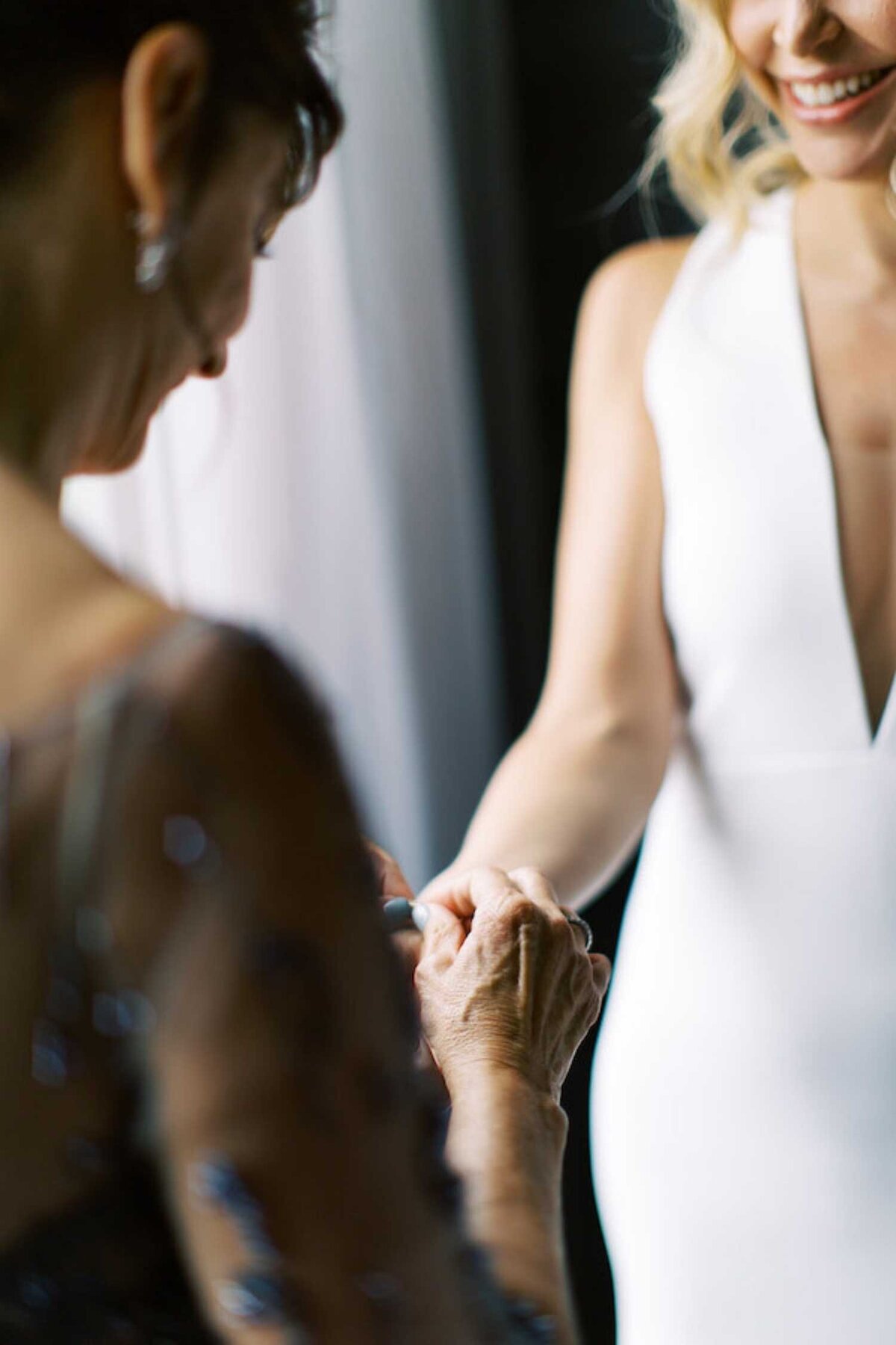 Mother of the Bride helps with final dressing for a modern bride during a luxury Chicago outdoor garden wedding.