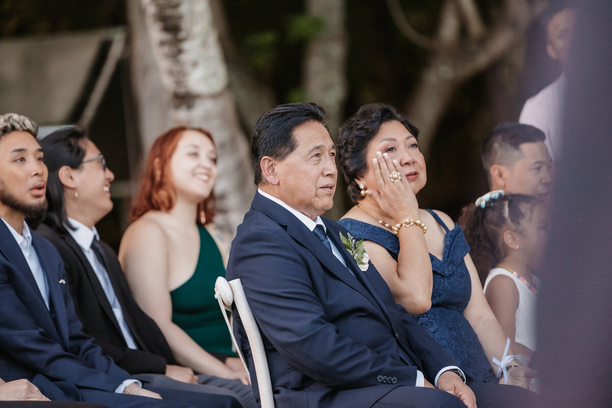 Wedding ceremony mother wiping away tear while watching the wedding wearing navy blue