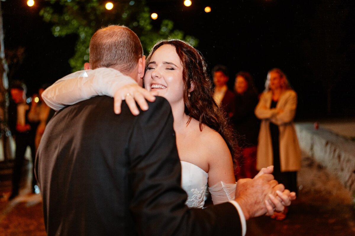 A heartwarming moment captured: a couple swaying together on the dance floor at their wedding reception, enveloped in love and joy.