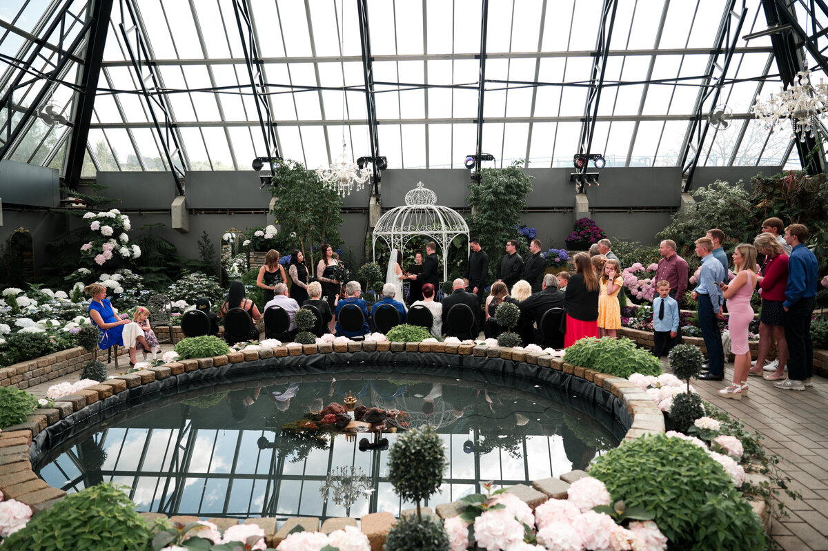 wide angle photograph of a beautiful wedding ceremony at the Muttart Conservatory in Edmonton, Alberta