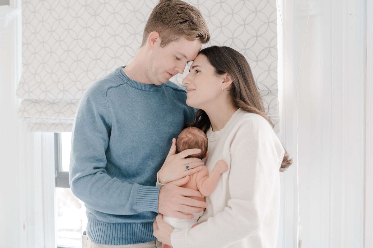 Natural light newborn portraits in Danville bedroom with soft beige tones.